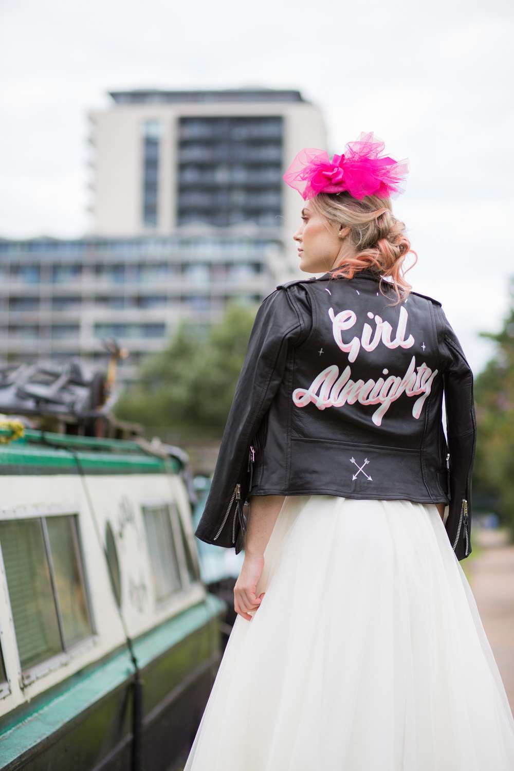 wedding inspiration of bride walking by canal boat wearing shocking pink veil and Laurie Lee designed biker jacket emblazoned with "Girl Almighty" - brand photography for wedding vendors