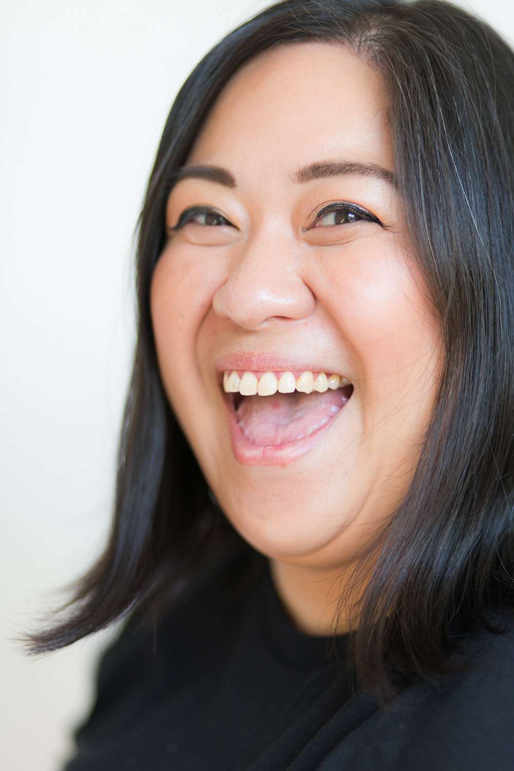 headshot of a female comedian laughing